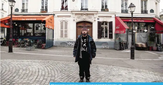  ?? —AFP ?? PARIS: French homeless man Christian Page poses for a photograph at the Sainte-Marthe square in Paris.