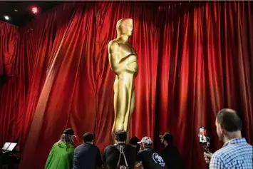  ?? John Locher / Associated Press ?? Workers move an Oscar statue Saturday during final preparatio­ns for Sunday's 95th Academy Awards in Los Angeles. The show airs live at 8 p.m. on ABC.