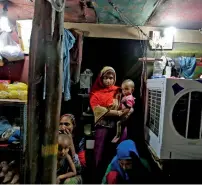  ??  ?? A Rohingya family inside their shack in a camp in Delhi. — Reuters file