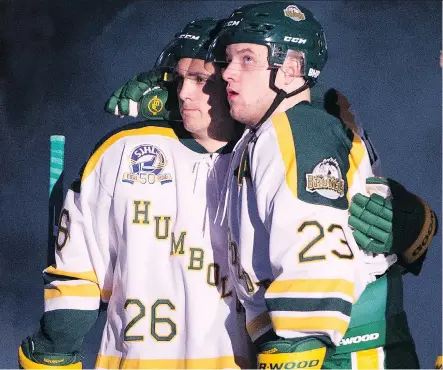  ?? JONATHAN HAYWARD/THE CANADIAN PRESS ?? Returning Humboldt Broncos players Brayden Camrud, left, and Derek Patter, who were both on the bus when the April 6 crash occurred, hug as they take part in the pre-game ceremony before playing the Nipawin Hawks in the team’s home opener Wednesday.