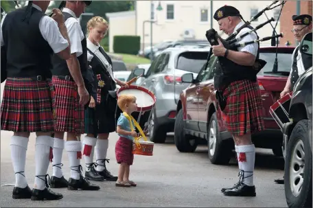  ?? PHOTOS BY TIM MARTIN/THE DAY ?? Above, Ray McNab, 2, of Groton stands next to his mother, Kristin McNab, to his left, a drummer with the Mystic Highland Band, and practices his drum rudiments Sunday as he watches Kevin Miller, second from right, a bagpiper with the Mystic Highland...