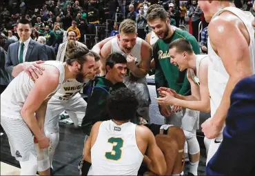  ?? PAUL SANCYA / ASSOCIATED PRESS ?? Wright State players celebrate their 74-57 win against Cleveland State with Ryan Custer on Tuesday. “Ryan’s a big part of this team. I just wanted him to be part of the moment,” said Parker Ernsthause­n.
