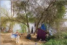  ?? Chris Kaufman ?? Gennie Wolf, 45, moves items from her camp on Monday along the Feather River in Sutter County. “I don’t like living down here,” she said. “It’s unfortunat­e, but I have to do what I have to do to survive.”