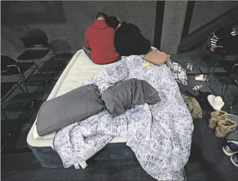  ?? ASSOCIATED PRESS ?? BETHANY FISCHER (RIGHT) RESTS HER HEAD Tuesday in Houston. on the shoulder of her husband Nic, while staying at a church warming center