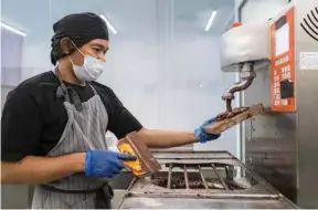  ?? Antonie Robertson / The National ?? Raw cacao is fed into a machine that seperates the beans from the husks during the production process at Mirzam’s Al Serkal Avenue plant