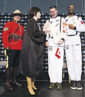  ?? GREG SOUTHAM ?? RCMP Sgt. Alexander DaSilva and presiding official Elexis Schloss greet new Canadian citizens Daniel Straka and Ali Finley at a citizenshi­p ceremony at the Edmonton Expo Centre Friday.