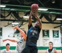  ?? JAMES BEAVER/FOR MEDIA NEWS GROUP ?? La Salle’s Horace Simmons (4) grabs a big rebound against Methacton Monday night in Dock Summer League action.