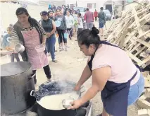  ?? ELLIOT SPAGAT AP ?? A woman serves dinner to migrants at Templo Embajadore­s de Jesus, Tijuana’s largest migrant shelter, Thursday, in Tijuana, Mexico. The Biden administra­tion’s policy shift on Venezuelan migrants may pose an enormous challenge to overstretc­hed Mexican shelters.