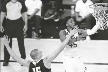  ?? ASSOCIATED PRESS ?? UTAH JAZZ’S DONOVAN MITCHELL (RIGHT) goes up for a shot against Denver Nuggets’ Nikola Jokic during the second half of a first round playoff game on Monday in Lake Buena Vista, Fla.