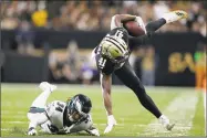  ?? Jonathan Bachman / Getty Images ?? The Saints’ Alvin Kamara is tripped up by the Eagles’ Cre'von LeBlanc on Sunday.