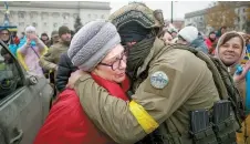  ?? Reuters-Yonhap ?? A local resident hugs a Ukrainian serviceman as people celebrate after Russia’s retreat from Kherson, in central Kherson, Ukraine, Saturday.