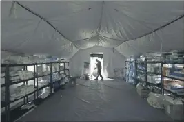  ?? ELAINE THOMPSON — THE ASSOCIATED PRESS FILE ?? A soldier walks inside a mobile surgical unit being set up by soldiers fromFort Carson, Col., and Joint Base Lewis-McChord (JBLM) in Seattle.