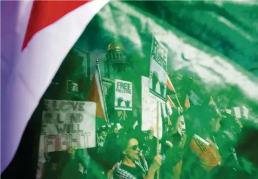  ?? (DENVER, LE 5 NOVEMBRE 2023/JASON CONNOLLY/AFP) ?? Des manifestan­ts, perçus à travers un drapeau palestinie­n, alors qu’ils prennent part à un rassemblem­ent de soutien à l’automne dernier.