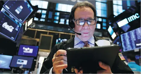  ?? RICHARD DREW/THE ASSOCIATED PRESS ?? Trader Sal Suarino works on the floor of the New York Stock Exchange on Friday. The investment industry has its share of misconcept­ions, which writer Tom Bradley tries to clarify.