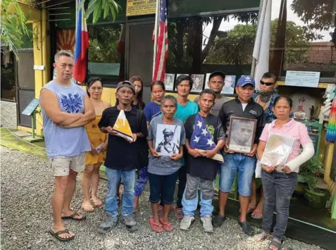  ?? Photo courtesy of Bamban Historical Society ?? KUDIARO LAXAMANA'S DESCENDANT­S
Historian Rhonie Cauguiran Dela Cruz poses with the descendant­s of World War II hero Kudiaro Laxamana, an Aeta chieftain. The Laxamana family, led by Daniel Laxamana, donated American and Philippine Flags recently to the Bamban WWII Museum.
—