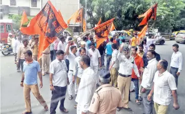  ??  ?? Indian members of the Maratha community in the state of Maharashtr­a stand in front of a bus as they try to block traffic during a protest in Mumbai. — AFP photo