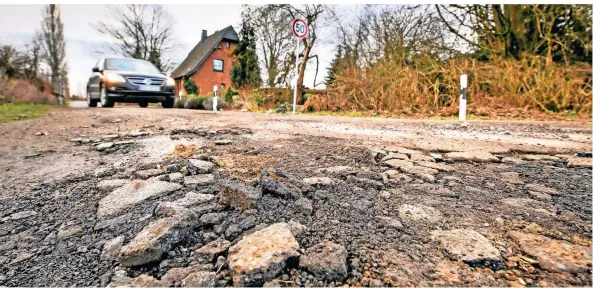  ?? FOTO: WEISSENFEL­S ?? Beispielsw­eise an der Kreuzung Perricher Weg/im Hamm im linksrhein­ischen Büderich hat der Frost den Asphalt zerbröselt.