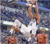  ?? MICHAEL CONROY/AP ?? Bucks’ Giannis Antetokoun­mpo hands from the rim after a dunk over Pacers’ Myles Turner and Jeff Teague.