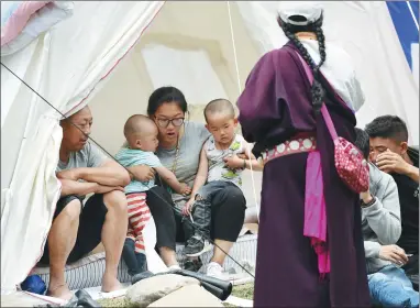  ?? ZHANG LANG / CHINA NEWS SERVICE ?? Earthquake victims rest in tents in Jiuzhaigou on Thursday. All those in need have received shelter.