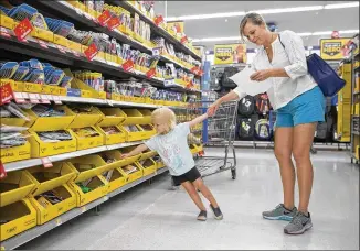  ?? JAY JANNER / AMERICAN-STATESMAN ?? Landry Purcell, 3, helps her mother, Robin, shop for her prekinderg­arten school supplies at a Walmart in Southwest Austin on Friday, taking advantage of the tax-free weekend, which runs through Sunday. Crowds are expected, so plan your shopping trip...