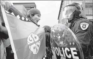  ?? AP/The Deseret News/LAURA SEITZ ?? Anthony Fierro confronts a police officer Monday in Salt Lake City. Fierro and other protesters were stopped from marching toward the Utah Capitol during President Donald Trump’s announceme­nt that he was scaling back two national monuments in the state.