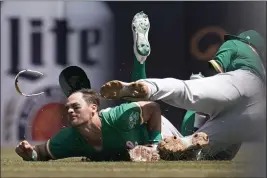  ?? PAUL SANCYA — THE ASSOCIATED PRESS ?? A's left fielder Chad Pinder, left, and shortstop Elvis Andrus collide while trying to field a pop fly by the Tigers' Harold Castro that landed for a single in the fifth inning on Tuesday in Detroit.