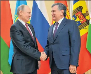  ?? AP PHOTO ?? Russian President Vladimir Putin, left, and Uzbekistan’s President Shavkat Mirziyoyev shake hands ahead of an informal meeting of the CIS (Commonweal­th of Independen­t States) leaders at the Novo-Ogaryovo residence outside Moscow, Russia.