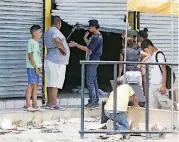 ?? [AP PHOTO] ?? People stand Sunday in front of a store that has been forced open and looted in Managua, Nicaragua. Dozens of shops in the Nicaraguan capital have been looted in the continuati­on of protests and disturbanc­es sparked by government social security reforms.