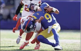  ?? Adam Hunger / Associated Press ?? Los Angeles Rams quarterbac­k Matthew Stafford (9) is tackled by New York Giants cornerback Darnay Holmes during Sunday’s game in East Rutherford, N.J.