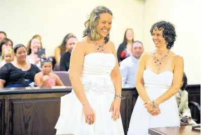  ?? AP ?? Lori Harvey (left) and her partner Amy Lipe exchange vows at the Civic Center in Evansville, Indiana, in June 2015. Cayman’s Chief Justice, Anthony Smellie, says countries will need to justify their position on same-sex marriage.