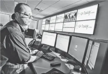  ?? TOM TINGLE/THE REPUBLIC ?? Martin Solum of Go Daddy investigat­es cyberattac­ks from the company’s Scottsdale security-operations center in 2011. Several businesses have cybersecur­ity teams in the Valley, and Arizona stands to gain from the industry’s growth.