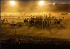  ?? IVAN PIERRE AGUIRRE — NEW YORK TIMES FILE ?? Migrants wait to be processed by U.S. Border Patrol agents as a dust storm descends May 11 in El Paso. The migrant busing program altered the debate over immigratio­n. Gov. Greg Abbott wants to give Texas police expanded powers over border enforcemen­t.