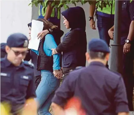  ?? MOHD YUSNI ARIFFIN
PIX BY ?? Doan Thi Huong (face covered) being escorted by police at the Sepang Court Complex yesterday.