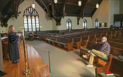  ?? Steve Mellon/Post-Gazette ?? Pastor Donna Giver-Johnston preaches to an empty sanctuary and an online audience on Sunday at Community Presbyteri­an Church in Ben Avon. Concerned about the spread of COVID-19, church leaders told members of the congregati­on not to gather at the church but to join the service via livestream. The church has been livestream­ing its services for the past two years. Ms. Giver-Johnston urged listeners to check on those most vulnerable to the virus and the disruption­s caused the its spread. “Together, we can get through this,” she said. At right is her spouse, Brian Johnston.