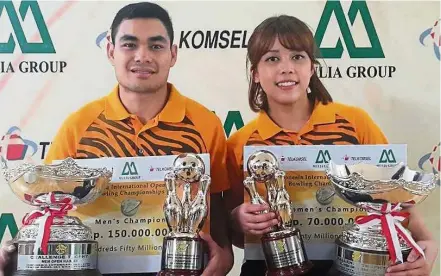  ??  ?? Double joy: Malaysian bowlers Ahmad Muaz Fishol and Siti Safiyah Amirah Abdul Rahman posing with their prizes after winning the men’s and women’s Masters titles at the Indonesian Open in Jakarta yesterday.