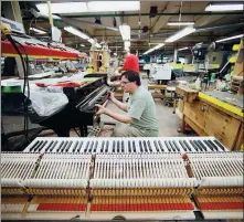  ?? BLOOMBERG ?? An employee installs an action assembly at the Steinway Piano Factory in Queens, New York.