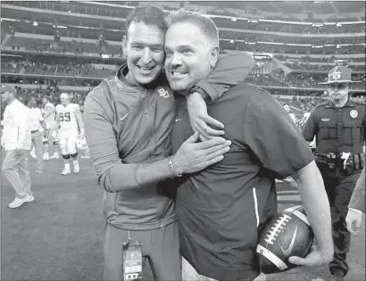  ?? Jerry Larson Waco Tribune-Herald ?? MACK RHOADES, left, athletic director, congratula­tes coach Matt Rhule after Baylor beat Texas Tech for win No. 6.