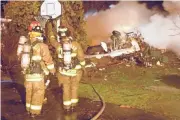  ?? DAVE SHERMAN/AP ?? Firefighte­rs look over the wreckage of Colgan Flight 3407 after the plane crashed into a suburban Buffalo home in 2009.