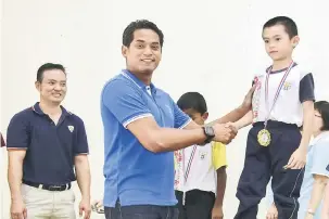  ?? — Gambar Bernama ?? TAHNIAH: Khairy (dua kiri) menyampaik­an hadiah kepada murid yang memenangi Hari Sukan Sekolah Rendah Jenis Kebangsaan (C) Chung Hua, Seremban semalam.