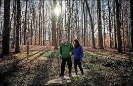  ??  ?? Patricia Cooper and her 70-year-old father, Wayne Cooper, walk in his backyard in McLean, Virginia. Their surgeries were on Dec. 5.