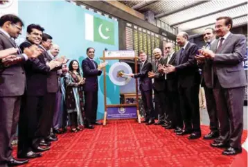  ?? — Reuters ?? David Hale, US Ambassador to Pakistan, strikes the ceremonial gong during his visit to the Pakistan Stock Exchange in Karachi, Pakistan, on Monday.