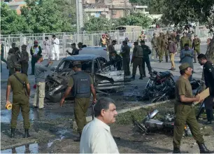  ?? AFP ?? Security officials inspect the site after the explosion in Lahore on Monday. —