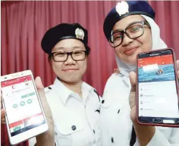  ??  ?? ... Malaysian Red Crescent members Tong Yi Ling and Nur Effa Qamarina Abdul Kalam showing the emergency call app on their cell phones during its launch in Dewan Brunsfield in Kuala Lumpur yesterday. The applicatio­n was set up in collaborat­ion with...