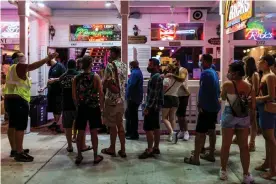  ?? Photograph: Saul Martinez/The Guardian ?? Code enforcemen­t inspector Troy Montero (right) makes sure people waiting online to enter a bar/restaurant social distance and wear protective face masks in Key West, Florida, on 18 September.