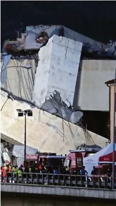  ?? AFP, AP ?? Wie Bauklötze türmen sich die Trümmer der Morandi-Brücke auf der Autobahn A10, rechts im Bild: ein Lkw, der in die Tiefe stürzte
