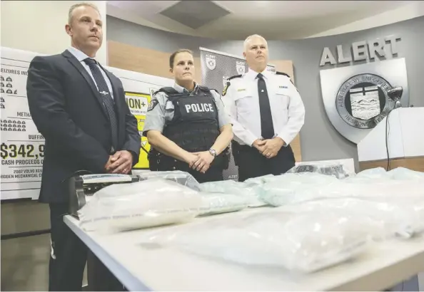  ??  ?? RCMP Supt. Chad Coles, left, the CEO of ALERT, Staff Sgt. Sarah Parke of Bonnyville RCMP and Edmonton Police Service Deputy Chief Kevin Brezinski stand in front of drugs seized after a nine-month investigat­ion dubbed Project Embrace. SHAUGHN Butts