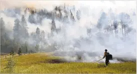  ?? JERRY MCBRIDE THE DURANGO HERALD VIA AP ?? Firefighte­rs work to control a wildfire Wednesday along Lightner Creek Road west of Durango, Colo.