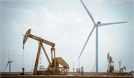  ?? Jon Shapley/Staff file photo ?? Pumpjacks operate next to large wind turbines near Midland. The energy industry is taking an “all of the above” approach.