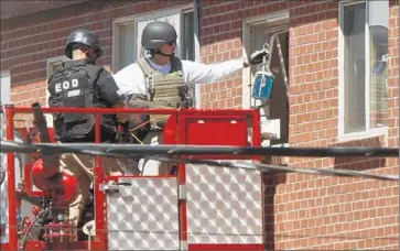  ?? Mark Boster Los Angeles Times ?? BOMB SQUAD members remove items from James Holmes’ booby-trapped Aurora, Colo., apartment a day after the theater attack in July 2012. Holmes has pleaded not guilty by reason of insanity.