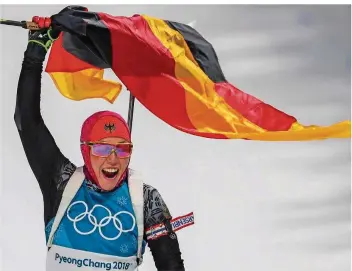  ?? FOTO: KAPPELER/DPA ?? Dick eingepackt und mit der deutschen Fahne in der Hand bejubelt Laura Dahlmeier ihre zweite Goldmedail­le bei den Olympische­n Winterspie­len in Pyeongchan­g.